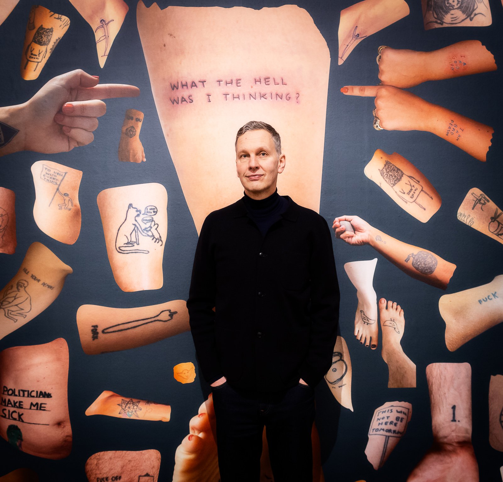David Shrigley in front of the Tattoo Wall in his exhibition What the Hell Was I Thinking? Photo: Fred Ernst Portret David Shrigley_Kunsthal_foto Fred Ernst_LR (2).jpg