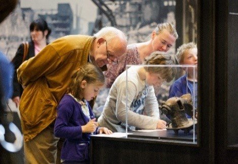 Opa met kleinkind in de tentoonstelling ‘Tweede Wereldoorlog in 100 voorwerpen’ (c) Fred Ernst bank.jpg