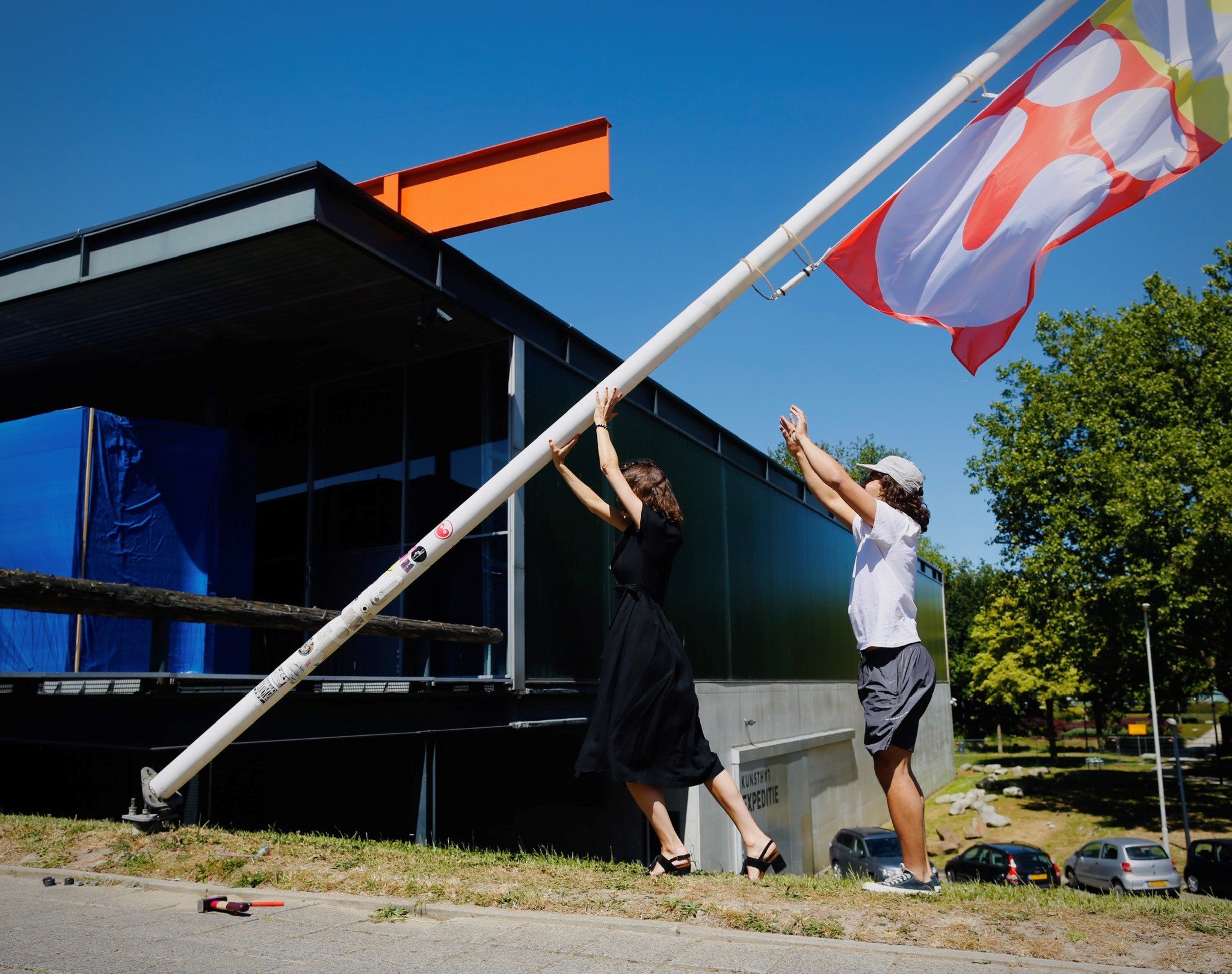 Directeur Nathanja van Dijk en kunstenaar Nazif Lopulissa hijsen de vlag ©Fred Ernst 5.jpg